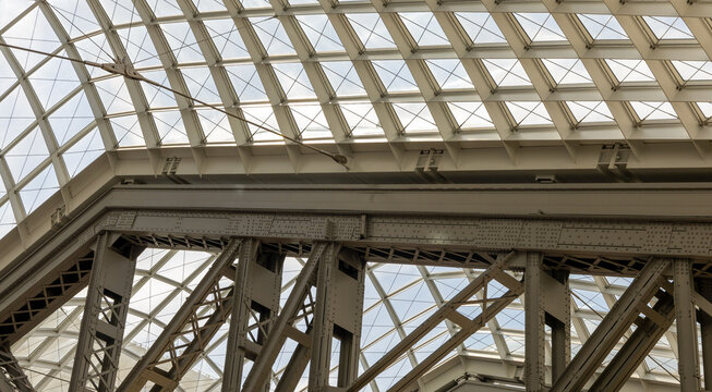Roof beams and glass ceiling in Moynihan Train Hall at Penn Station in New York City. - Powered by Adobe