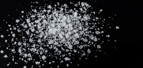 Crystalline salt granules scattered on a smooth black surface,  recipe,  texture