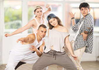 Fototapeta premium During hip hop dance lesson, girl leads, conducts classes, teaches students to correctly perform elements and sequence of movements and moonwalk