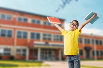 Happy child boy in class with book and glasses