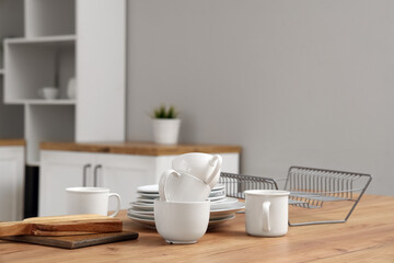 Plate rack, clean dishes and cutting boards on wooden kitchen counter