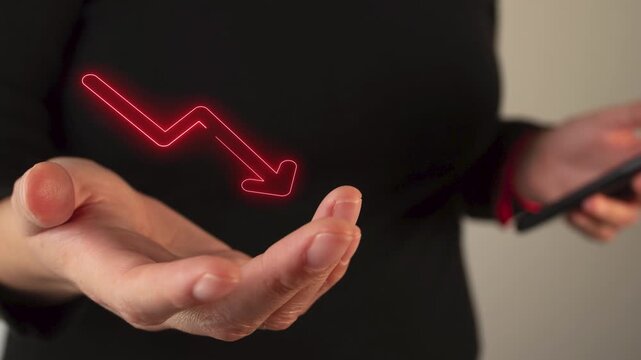 Businesswoman hand holding a virtual icon of arrow going down