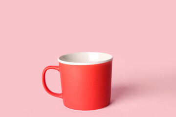Red ceramic cup on pink background