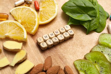 Composition with text IMMUNE SYSTEM, healthy food and pills on wooden background, closeup