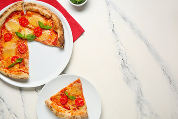 Plates with cut tasty pizza Margarita on white background