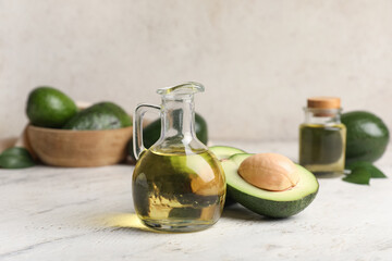 Jug of avocado oil on light background