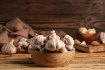 Bowl with fresh garlic on wooden background