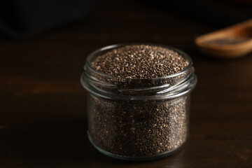 Jar with chia seeds on wooden background