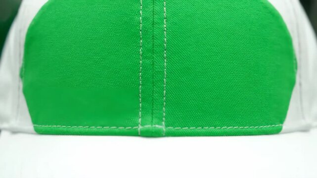 A Detailed Macro View of a Green and White Baseball Cap's Textured Fabric and Stitching