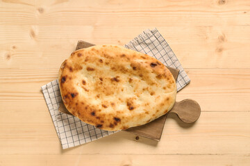Board with tasty lavash on wooden background