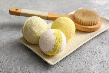 Composition with tray, massage body brush and bath bombs on grey grunge background, closeup