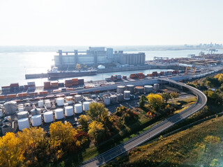 Obraz premium Aerial view of port industrial tanks and container yard near river in Montreal, Canada. g.