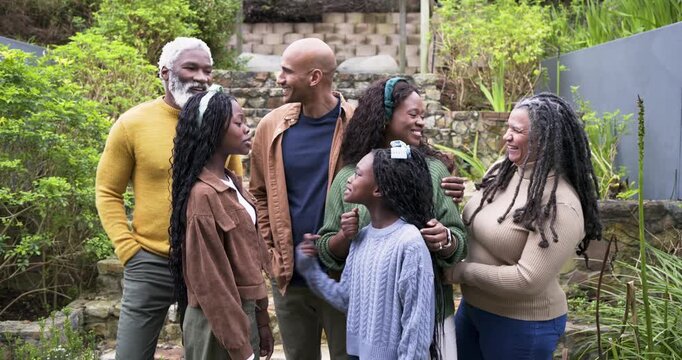 Diverse family gathering at backyard stone steps, adjusting poses, smiling after off-camera prompt