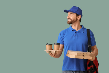 Male courier with pizza boxes and coffee cups on green background
