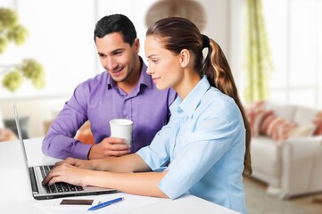 Young happy couple having fun using laptop