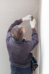 An electrician removes insulation from a copper wire. Working with the tool. Professional...