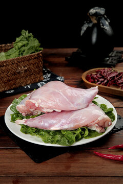 Fresh Raw Rabbit Forelegs on Plate with Lettuce and Asian Cooking Ingredients