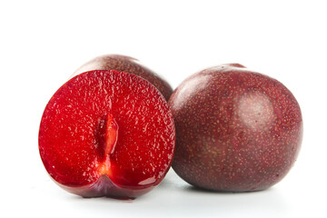 Fresh Red Plums Cut in Half Showing Juicy Interior on White Background