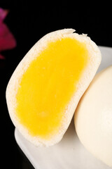 Golden runny egg yolk custard bun breakfast with creamy filling dripping on white plate