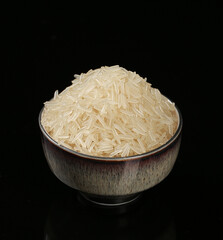 Bowl of Long Grain White Rice on Black Background - Uncooked Cereal Grains