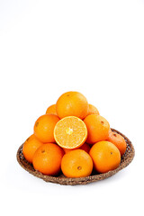 Fresh Navel Oranges in Wicker Basket with Half Cut Orange on White Background