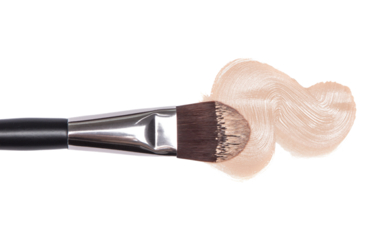 Makeup brush applying foundation swatch on black background