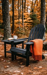 A relaxing outdoor scene showcases black Adirondack chairs with an orange throw blanket, nestled among colorful autumn leaves in a serene forest setting.