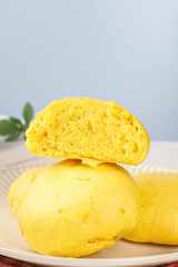Golden Pumpkin Bread Buns Closeup Display on Wooden Plate - Fresh Handmade Bakery Items