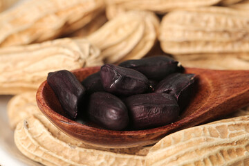 Black Selenium-Enriched Peanuts from Yunnan China in Wooden Spoon with Traditional Woven Baskets Background