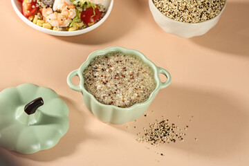 Cooked Tricolor Quinoa in Ceramic Pot with Raw Grains and Healthy Meal Setup