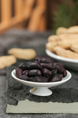 Yunnan Black Selenium-Enriched Peanuts and Regular Dried Peanuts in White Bowls on Slate Background