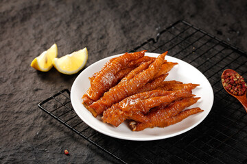 Braised Chicken Feet Dim Sum with Soy Sauce Glaze and Lemon Garnish on Slate Background