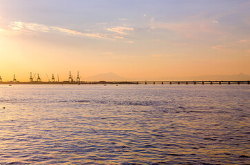 Tourists enjoying the sunset in the port area, a tourist attraction in the city of Rio de Janeiro, behind the Museum of Tomorrow with a view of the Rio-Niter&oacute;i bridge and reflecting pool.