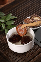 Fresh and Dried Shiitake Mushrooms in Bowl with Wooden Spoon - Asian Cooking Ingredients