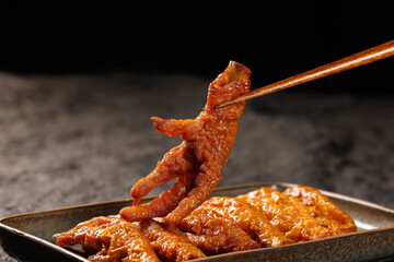 Marinated Chicken Feet with Chopsticks - Traditional Asian Delicacy Snack with Crispy Golden Skin