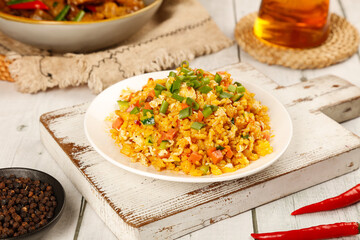 Yangzhou Golden Fried Rice Chinese Specialty with Egg and Vegetables on Rustic Wooden Board