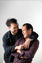 Young homosexuals gay couple love each other on a white background.