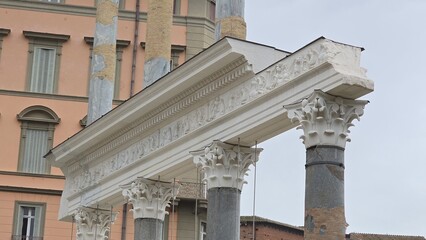 Rome, Italy - 11 January 2025. Restored Corinthian columns with detailed capitals and a white frieze rise at Trajan's Forum, partially reinforced and surrounded by modern architecture.