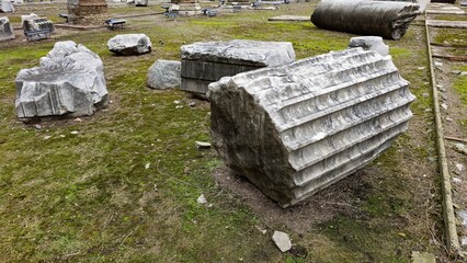 Rome, Italy - 11 January 2025. Fragmented marble columns rest on a grassy patch at Trajan's Forum,...