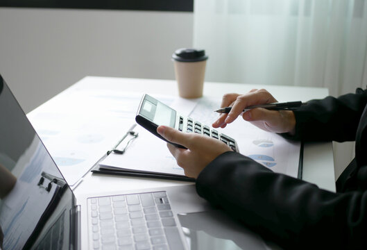 Young Asian business woman sitting at the table holding a pen, recording investments and planning the process of growing a successful business