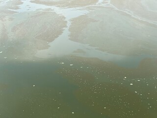 Abstract texture of a murky water surface with floating bubbles