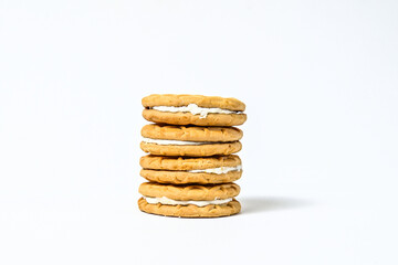 Side view of four biscuits isolated on white background. clipping path. pile, stack. milk biscuits with jam and cream. close up.
