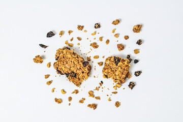 Two Granola bar with almonds, oats, and dried cranberries, isolated on a white background. Top view, high angle, above, Close up. clipping path. piece. Flat lay. broken. scattered. crumbs. cracked.