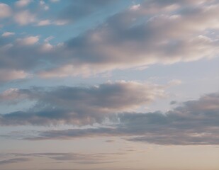 Fototapeta premium Soft pastel clouds at sunset against a serene blue sky.