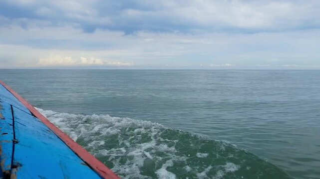 Beautiful ocean view from a boat in Pariaman, Indonesia, with foamy waves and a cloudy sky on the sea