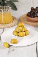 Roasted Chestnuts in White Bowl on Rustic Wooden Table with Autumn Food Styling