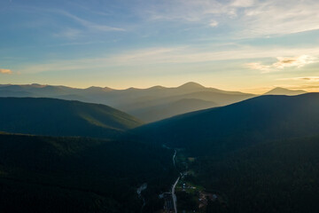 Fototapeta premium Beautiful mountain panoramic landscape with hazy peaks and foggy valley at sunset