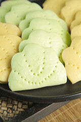 Handmade Traditional Lotus Leaf Shaped Cookies in Two Colors Green Yellow on Dark Plate