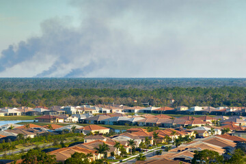 Prescribed fire smoke rising up over suburban neighborhood in Florida