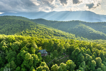 Remote house in mountain sunrise forest illuminated with bright rising sun in North Carolina Appalachian mountains. Tourist shelter as USA travel destination